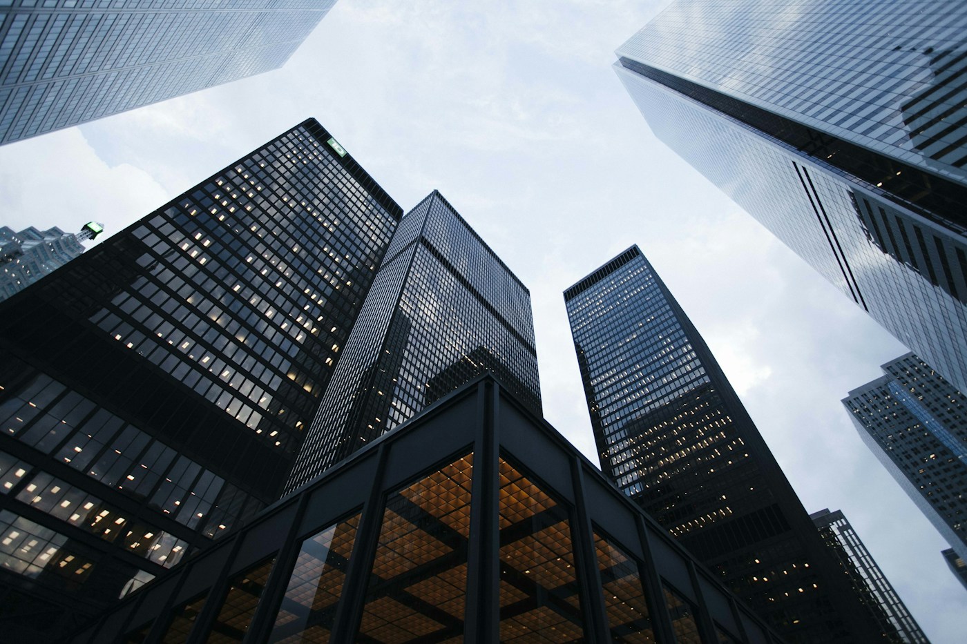 Intersecting glass building façades reflecting light and sky, echoing a precise digital design system