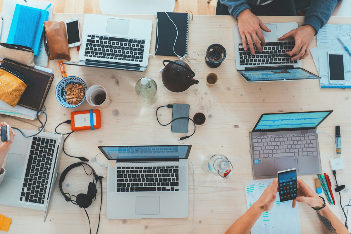 People working together with laptops at a shared table, representing digital experiences shaped around real users